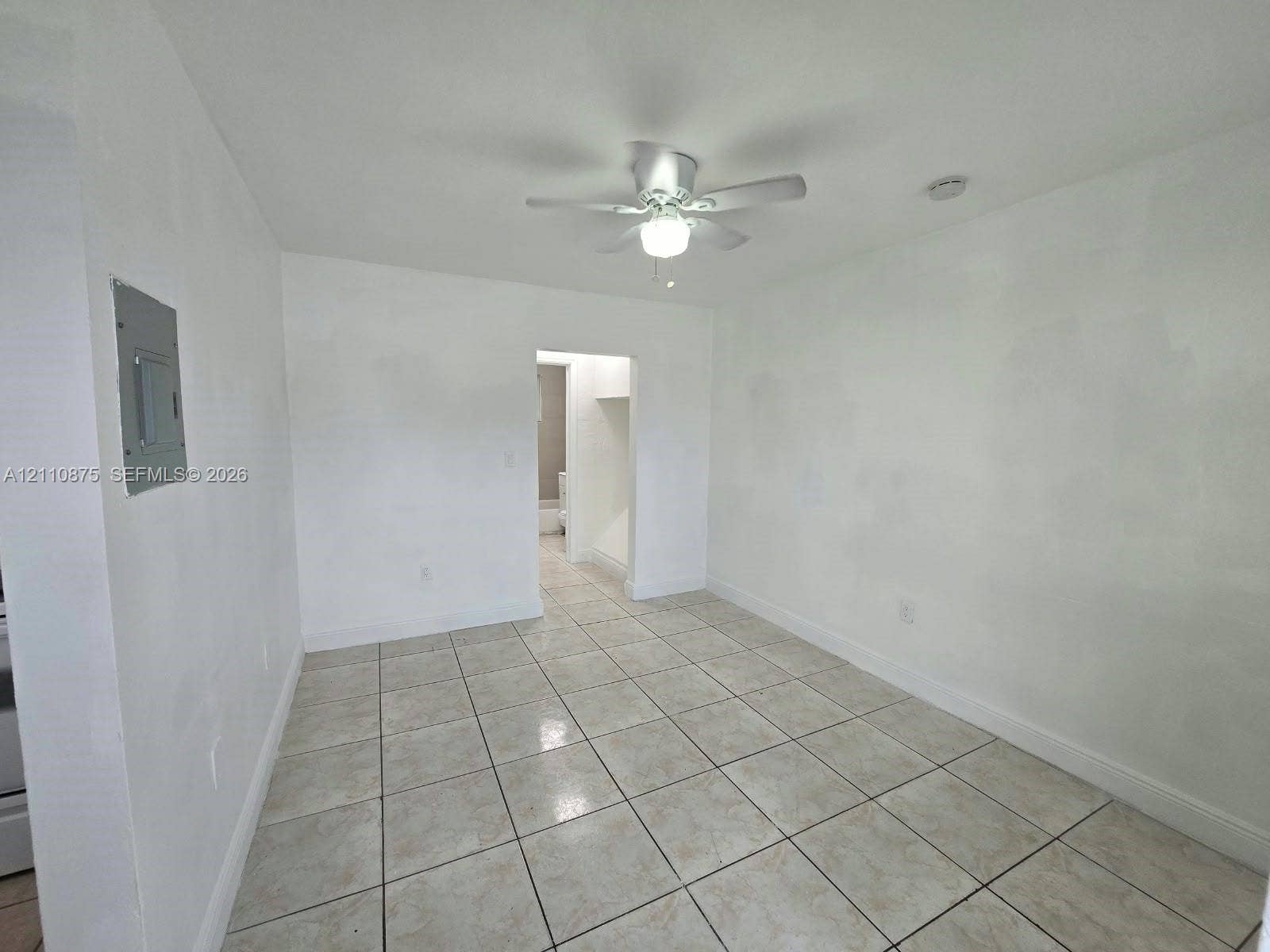 535 NW 7th Street, #10, Miami, Miami, FL 33136 Neutral-toned square tile flooring, white wall finishes, and a central ceiling fan with an integrated light fixture