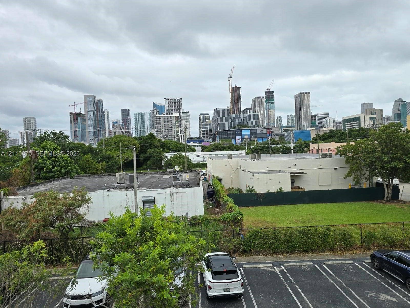 535 NW 7th Street, #10, Miami, Miami, FL 33136 Urban landscape featuring a high-rise skyline, paved parking area, and open green space