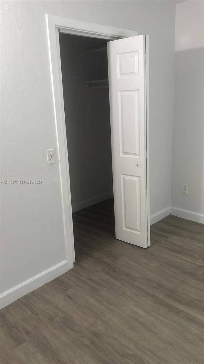 7230 NW 3rd Street, #4, Miami, Miami, FL 33126 Wood-finish flooring, neutral wall tones, and a closet featuring a three-panel door with interior shelving