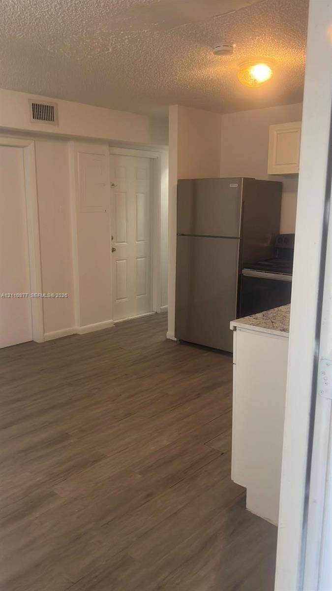 7230 NW 3rd Street, #4, Miami, Miami, FL 33126 Wood-finish flooring, stone-surfaced countertops, white shaker-style cabinetry, and stainless steel refrigerator