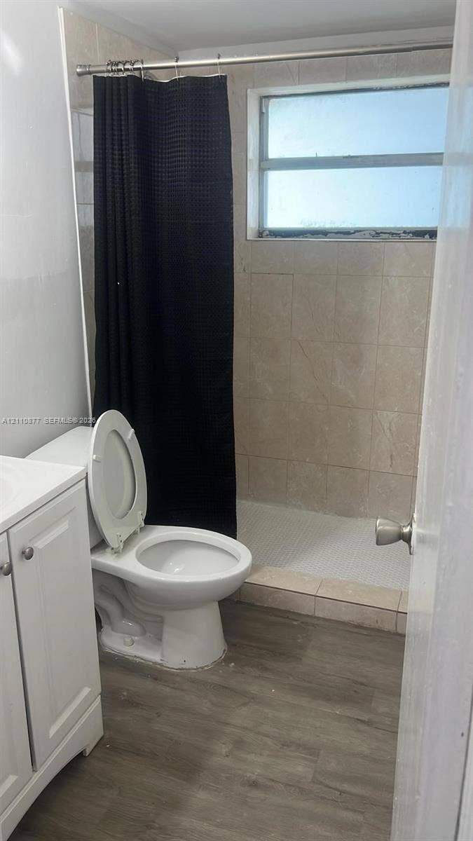 7230 NW 3rd Street, #4, Miami, Miami, FL 33126 Bathroom featuring a white vanity cabinet, wood-finish flooring, and a walk-in shower with neutral wall tiling and an integrated window