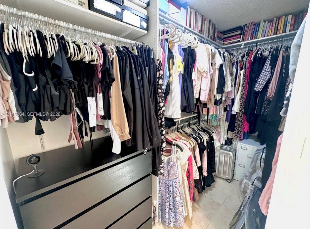 400 Diplomat Parkway, #805, Hallandale Beach, FL 33009 Walk-in closet featuring floor-to-ceiling custom shelving, tiered hanging rods, and integrated drawer storage