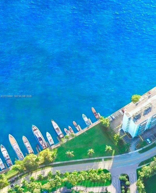 400 Diplomat Parkway, #805, Hallandale Beach, FL 33009 Aerial perspective of waterfront property featuring a concrete pier with deep-water boat slips, manicured grounds, and mature palm trees