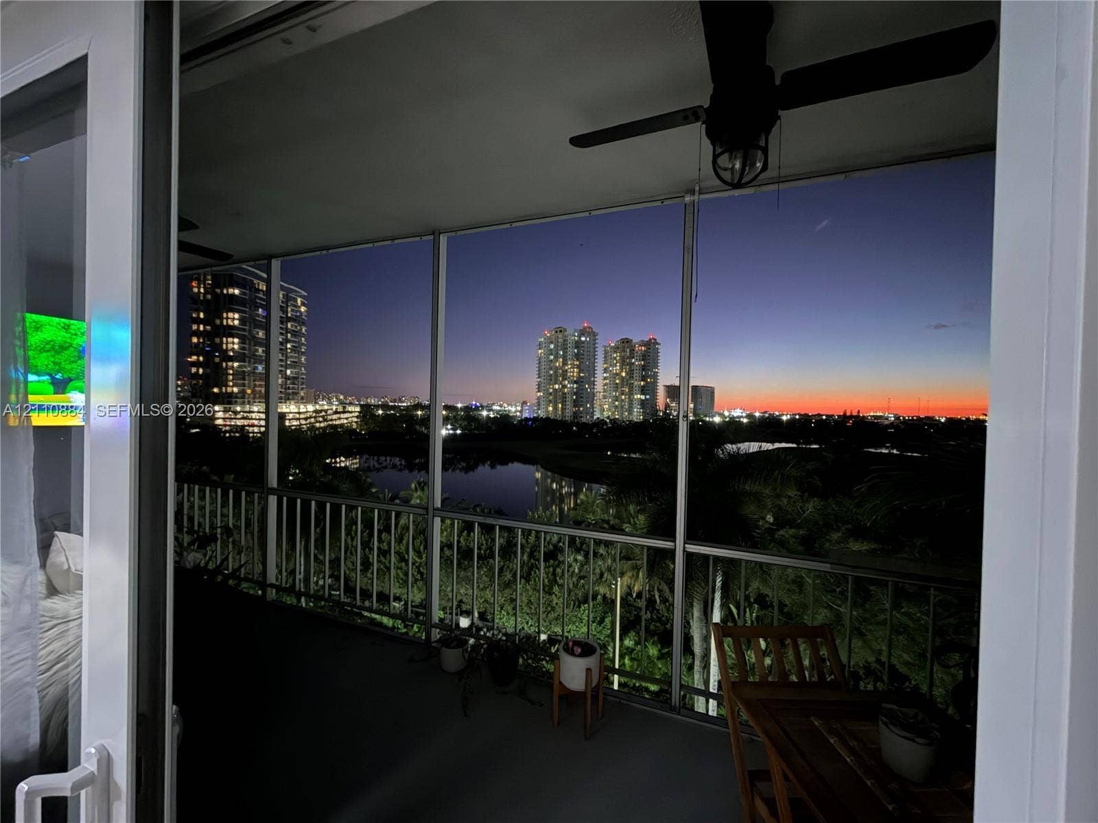 400 Diplomat Parkway, #805, Hallandale Beach, FL 33009 Screened balcony with metal railing, ceiling fan, and skyline and water scenery