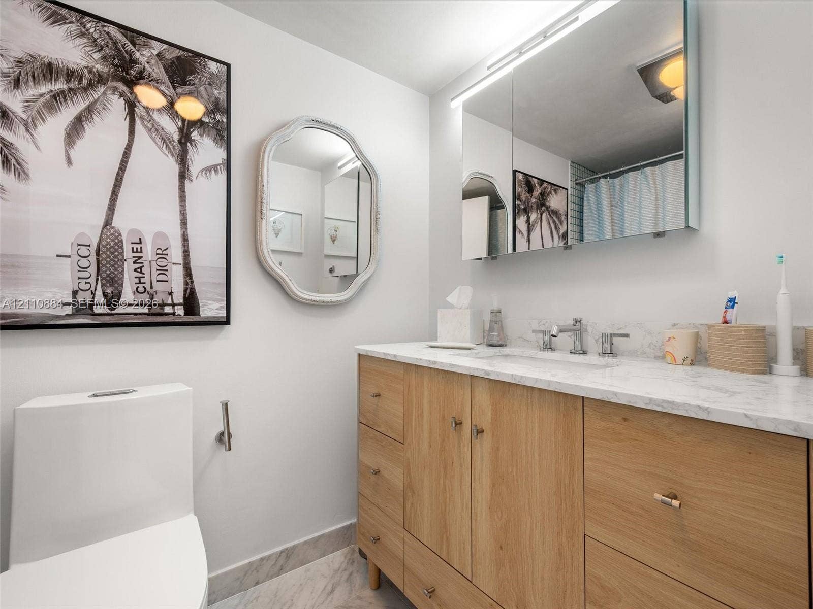 400 Diplomat Parkway, #805, Hallandale Beach, FL 33009 Wood-finish vanity with stone countertop, integrated undermount sink, dual-handle faucet, ultra-modern-mirrored medicine cabinet, and stone-patterned flooring