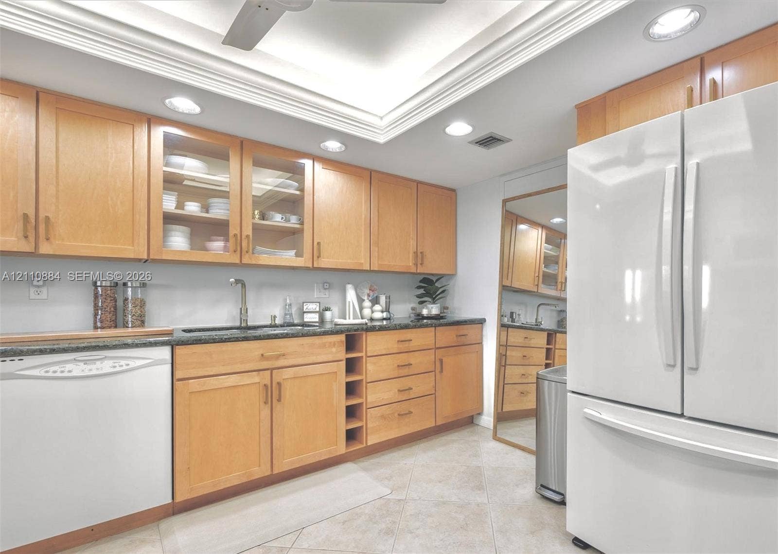 400 Diplomat Parkway, #805, Hallandale Beach, FL 33009 Kitchen featuring custom, sollid wood cabinetry, integrated glass-front display cabinets, jade stone countertops, recessed lighting, and a tray ceiling