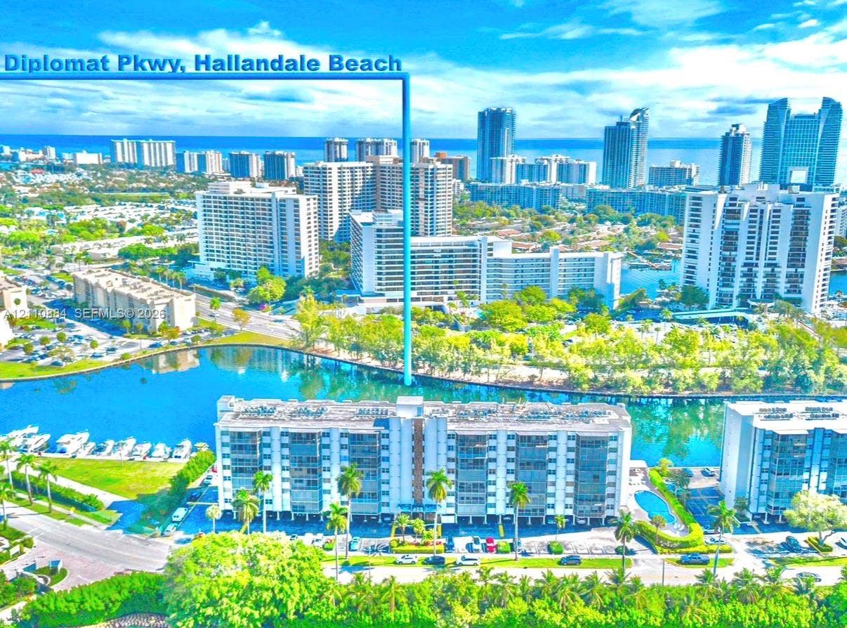 400 Diplomat Parkway, #805, Hallandale Beach, FL 33009 Aerial perspective of Diplomat Parkway featuring waterfront proximity, expansive waterway frontage, mature palm trees, and multi-story residential architecture