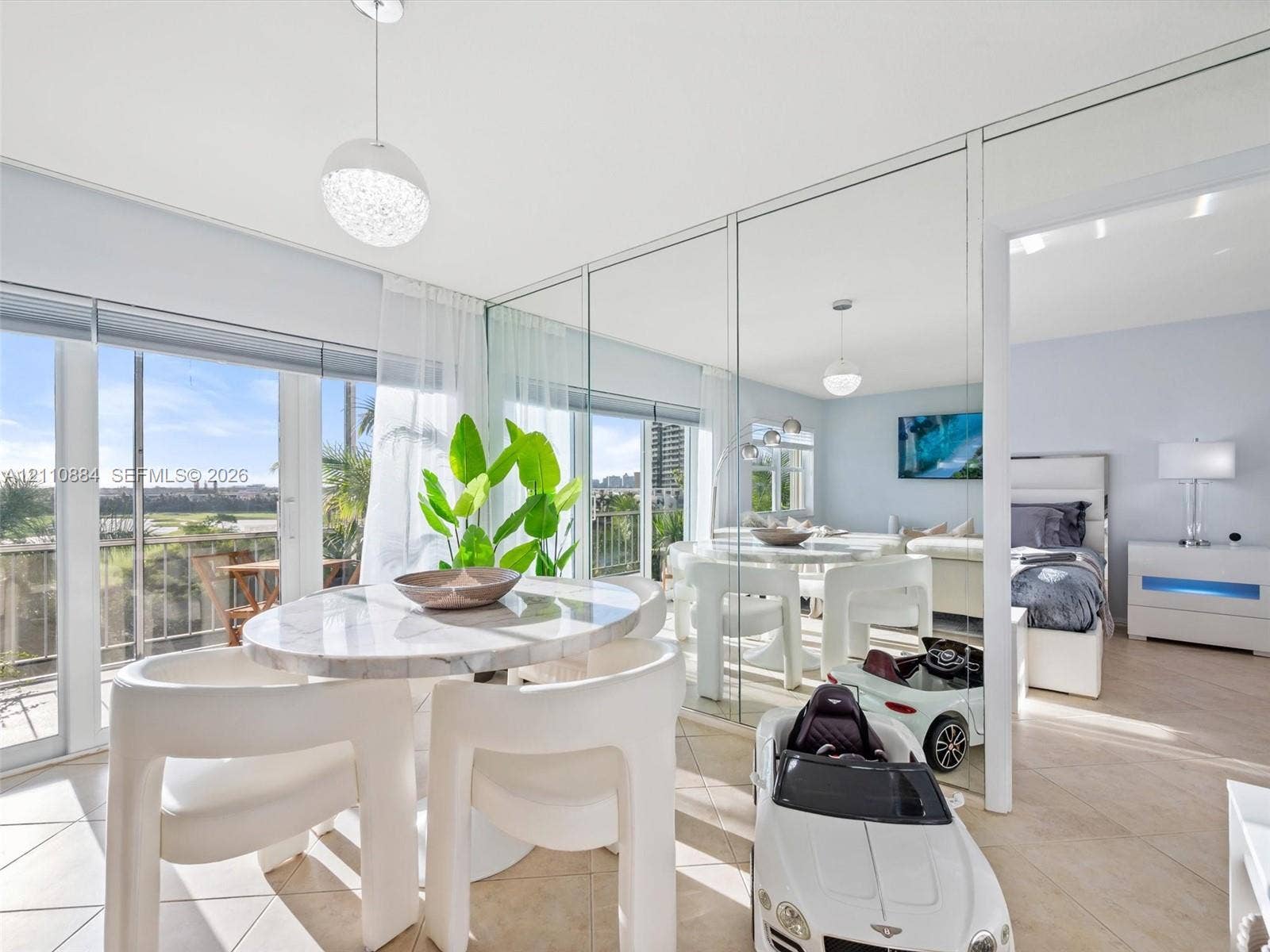 400 Diplomat Parkway, #805, Hallandale Beach, FL 33009 Floor-to-ceiling mirror wall, tile flooring, brand new impact rated glass sliding balcony doors, and custom spherical pendant lighting
