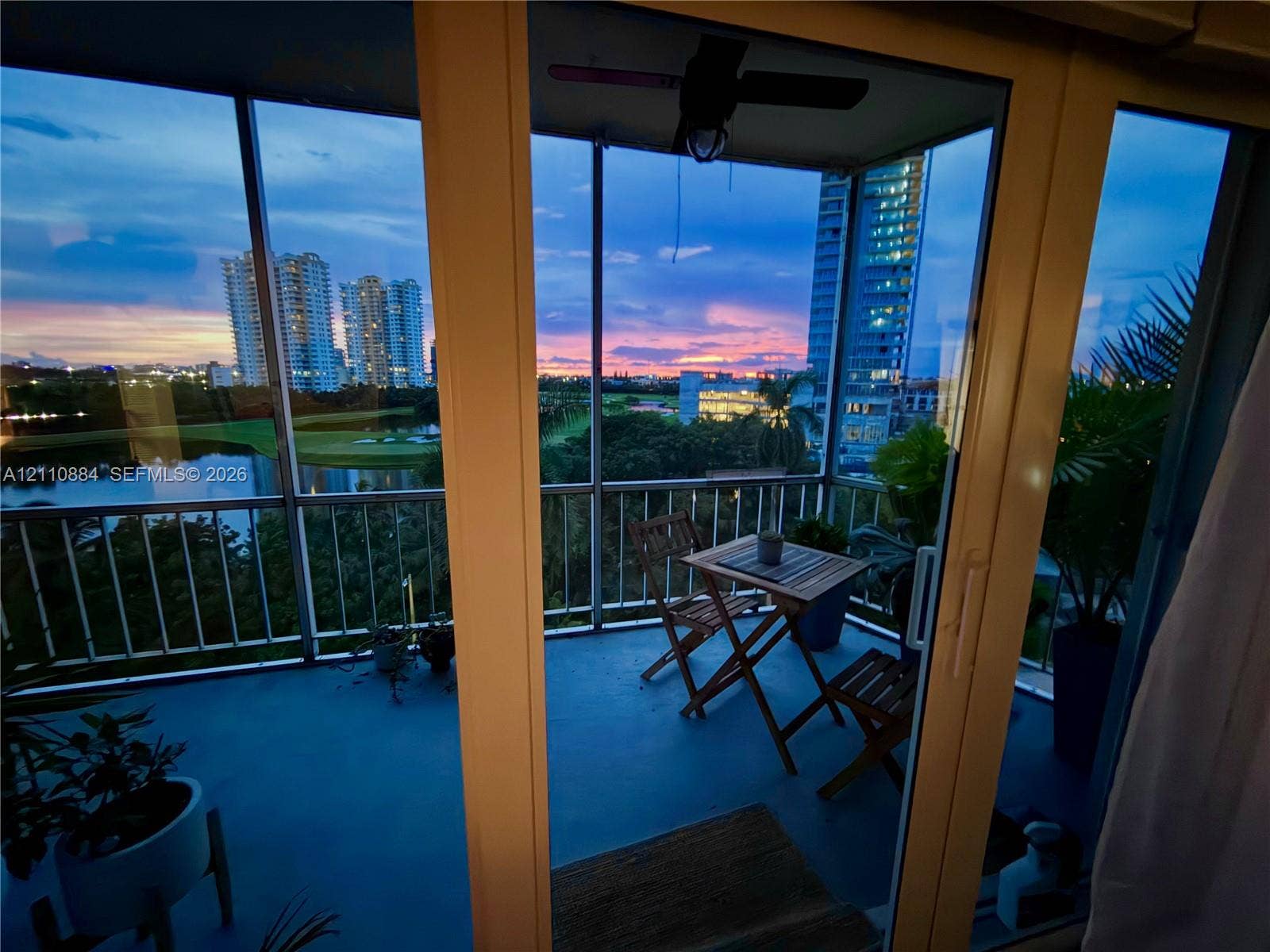 400 Diplomat Parkway, #805, Hallandale Beach, FL 33009 Screened-in balcony featuring sliding glass door access, metal railings, and overhead ceiling fan