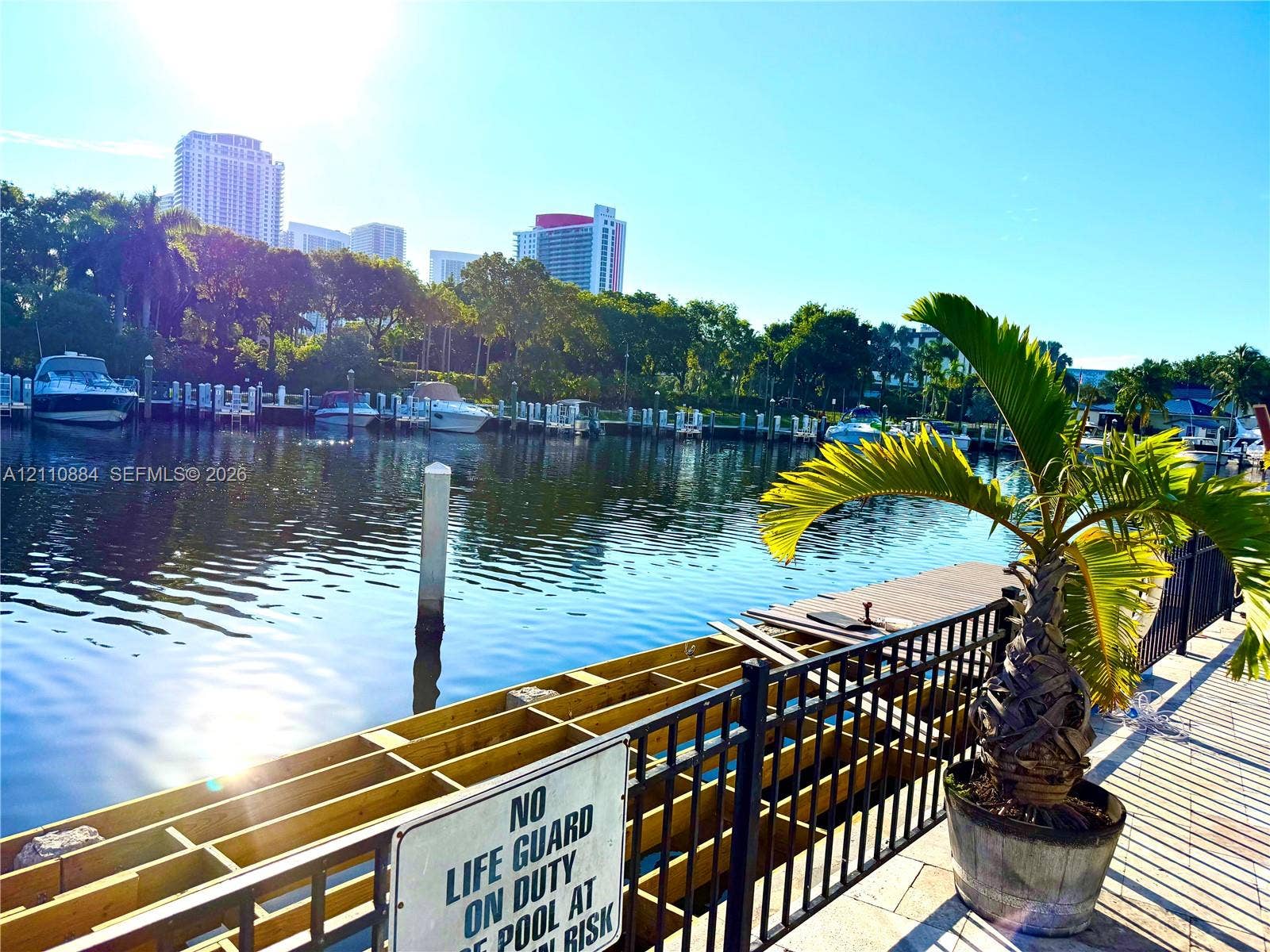 400 Diplomat Parkway, #805, Hallandale Beach, FL 33009 Waterfront bulkhead with timber framing, paved walking path, and black metal perimeter fencing