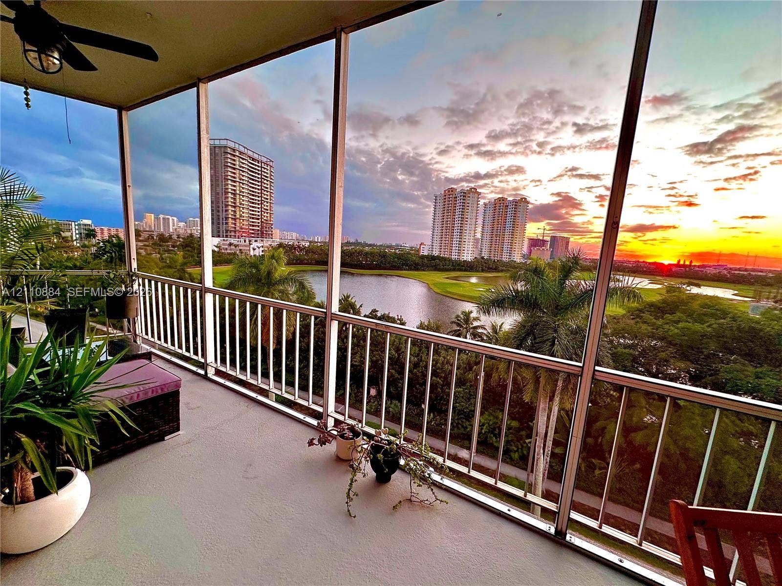 400 Diplomat Parkway, #805, Hallandale Beach, FL 33009 Screened-in balcony featuring white metal railings, a ceiling fan, and concrete flooring