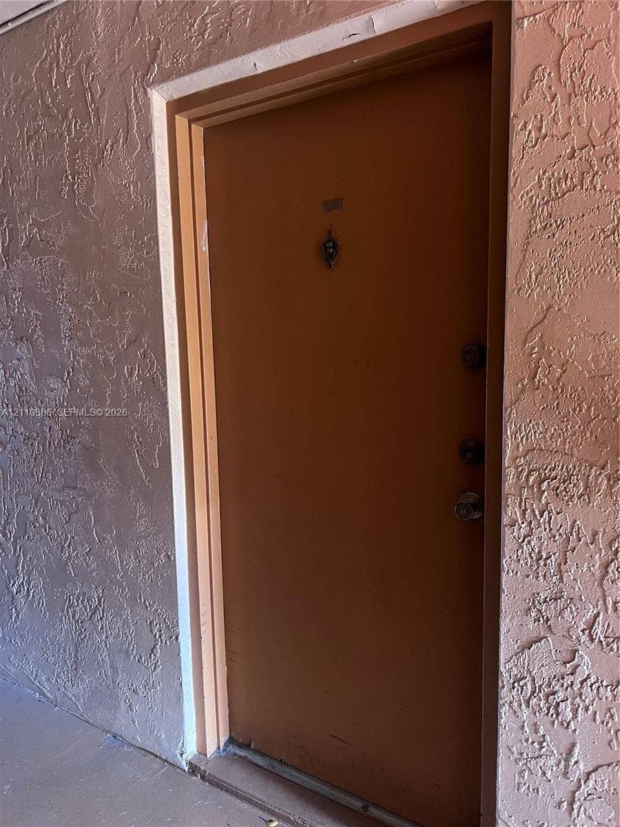 7101 Miami Lakes Drive, #Q12, Miami Lakes, Miami Lakes, FL 33014 Solid wood-finish door featuring a metal door knocker, dual deadbolt locks, and a metal door handle