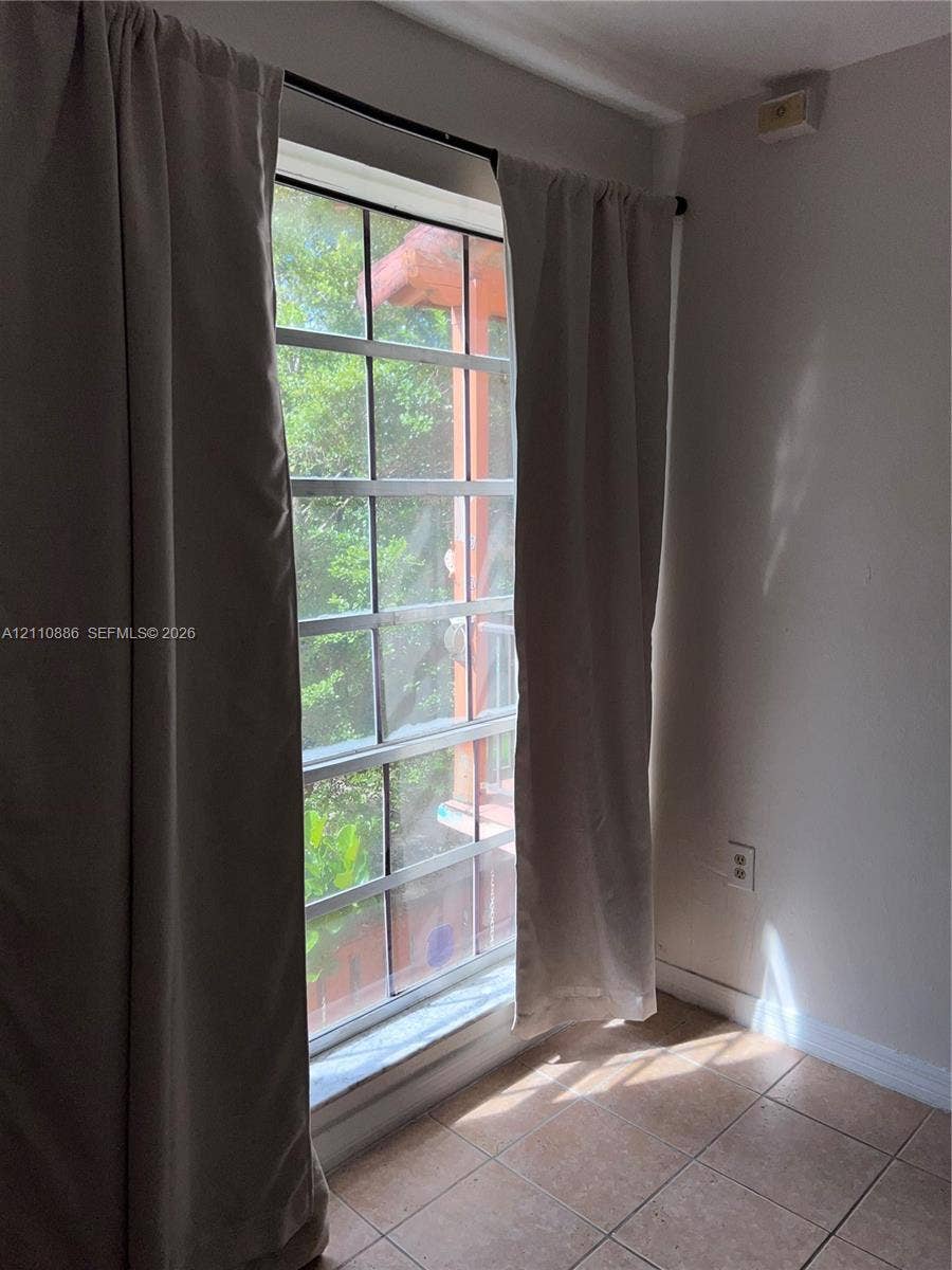 7101 Miami Lakes Drive, #Q12, Miami Lakes, Miami Lakes, FL 33014 Grid-patterned window with exterior ledge, neutral-toned tile flooring, and solid-colored walls
