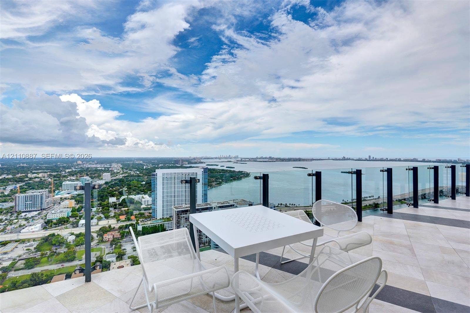 501 NE 31st Street, #4002, Miami, FL 33137 Expansive high-rise terrace featuring light-toned stone tile flooring and a frameless glass balcony railing
