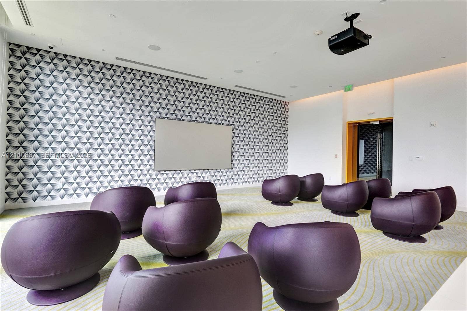 501 NE 31st Street, #4002, Miami, FL 33137 Room featuring a mounted projection screen, ceiling-mounted projector, patterned wall covering, recessed lighting, and integrated sound system speakers