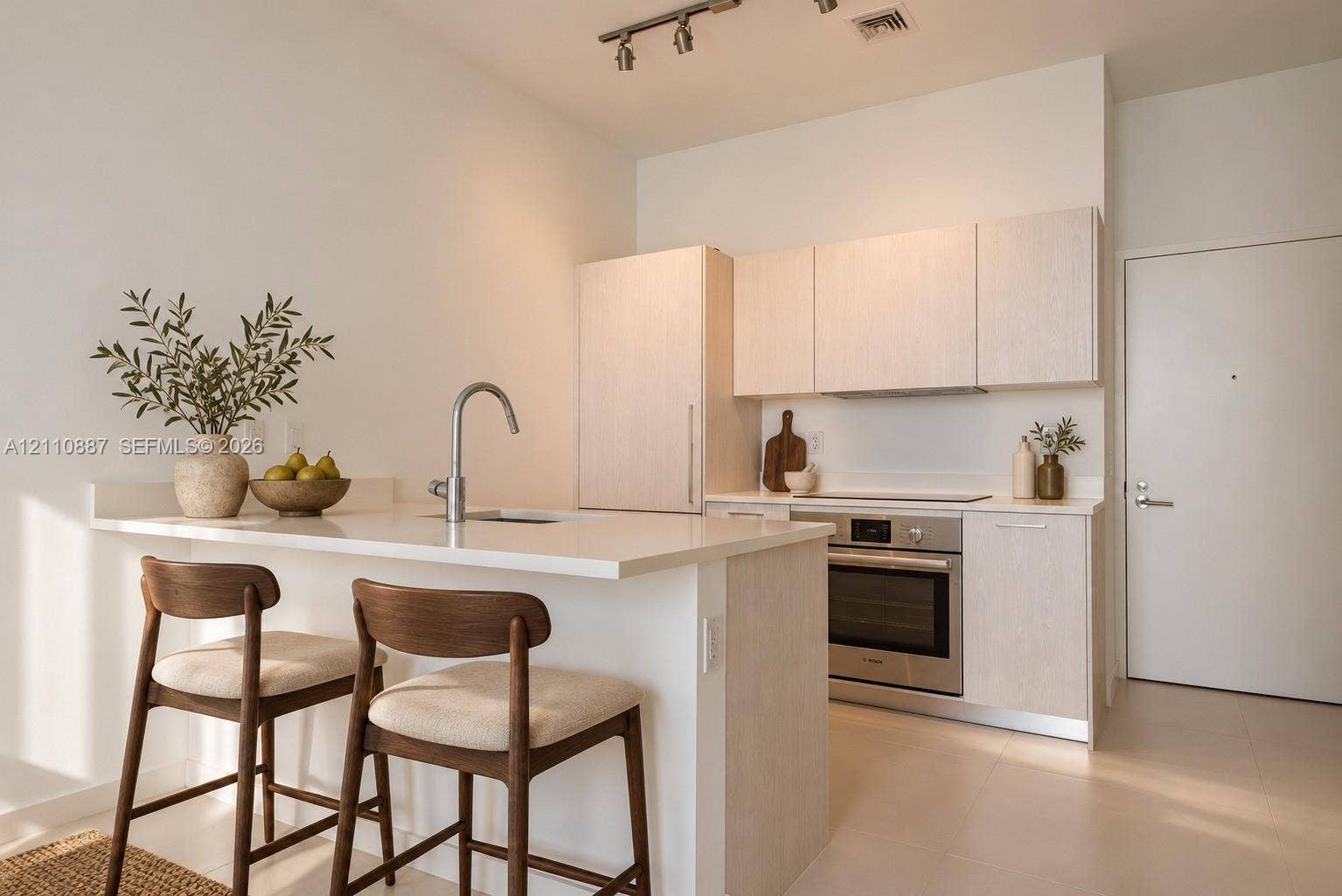 501 NE 31st Street, #4002, Miami, FL 33137 Kitchen featuring light-toned cabinetry, solid surface countertops, stainless steel oven, integrated refrigerator panel, and track lighting