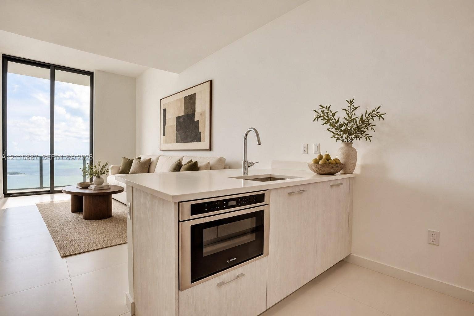 501 NE 31st Street, #4002, Miami, FL 33137 Kitchenette featuring light-finish cabinetry, quartz countertops, an integrated microwave, and a stainless steel undermount sink