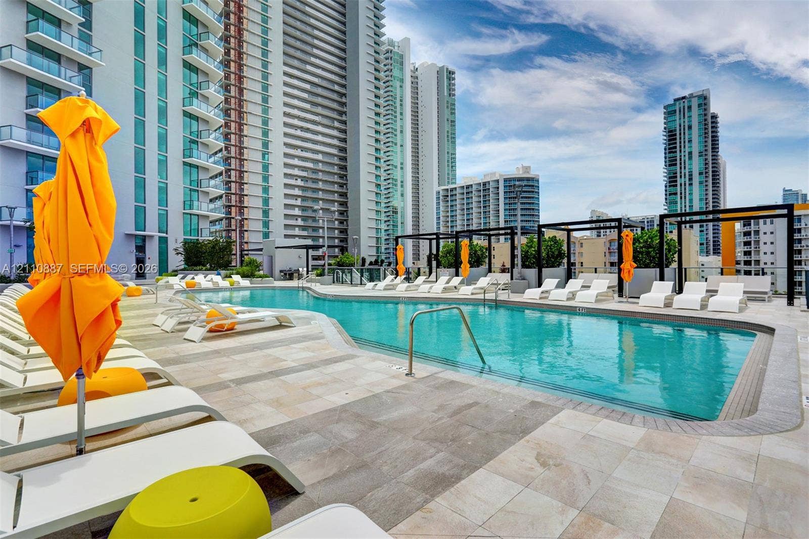 501 NE 31st Street, #4002, Miami, FL 33137 Swimming pool featuring stone tile decking, metal pergola structures, and integrated steel handrails