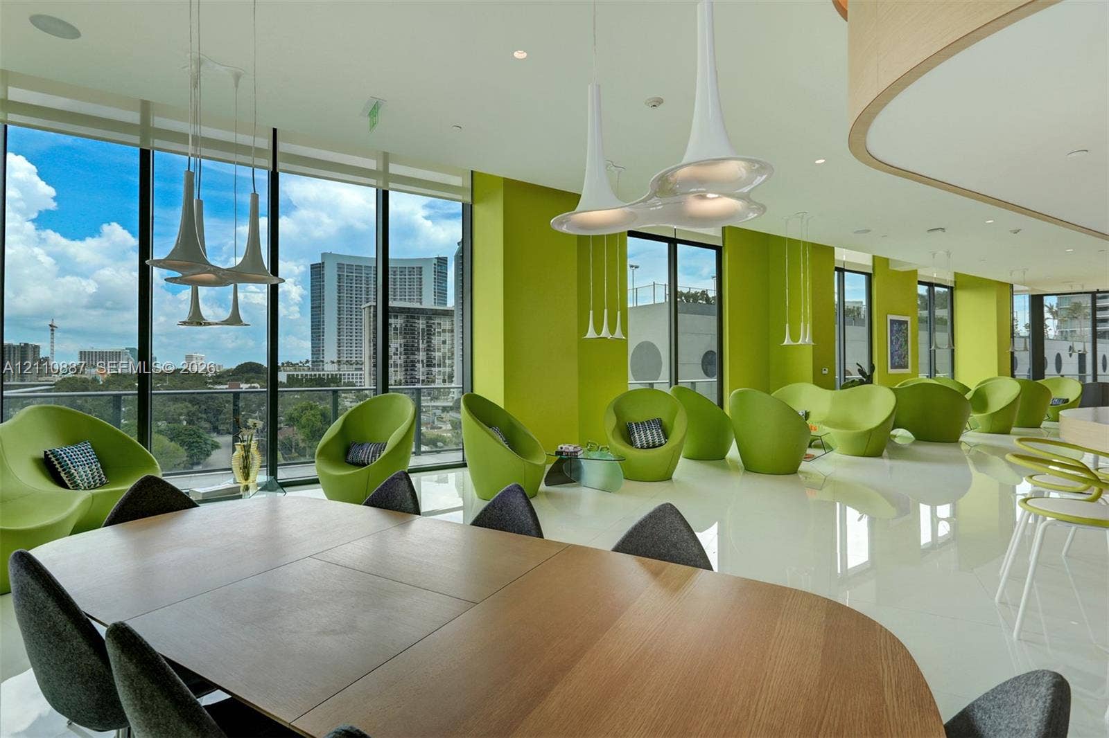 501 NE 31st Street, #4002, Miami, FL 33137 Floor-to-ceiling windows, high-gloss white flooring, contemporary pendant lighting, and a curved architectural wall feature