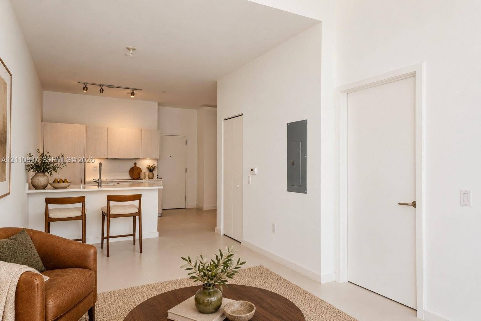 501 NE 31st Street, #4002, Miami, FL 33137 Kitchen featuring light-toned cabinetry, a peninsula with counter seating, track lighting, and solid-surface flooring
