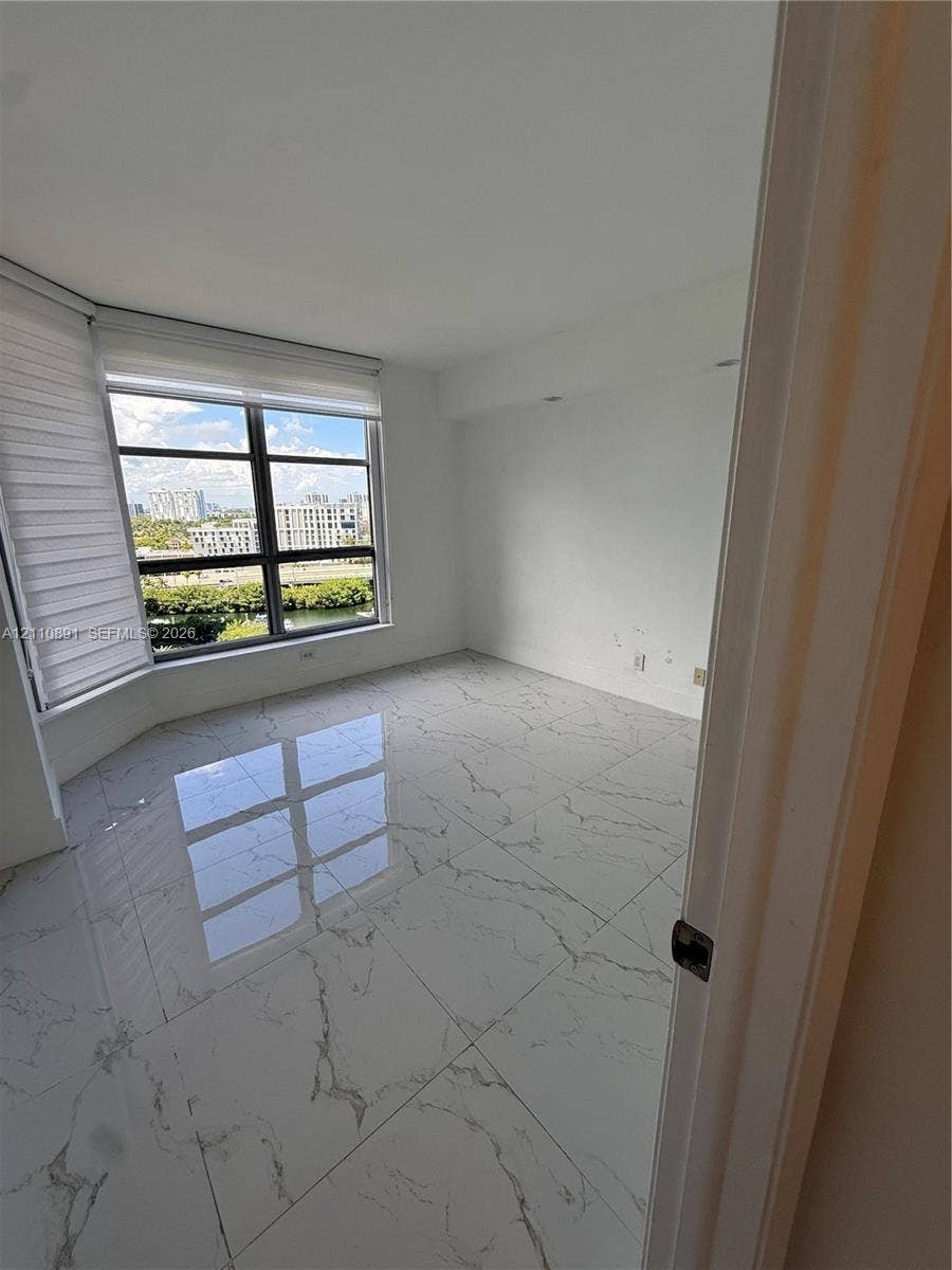 3600 Mystic Pointe Drive, #1611, Aventura, FL 33180 Room featuring large-format veined tile flooring and floor-to-ceiling windows with roller shades