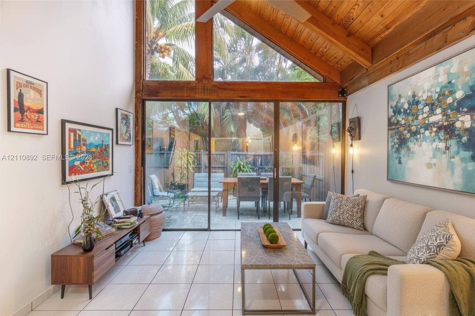 497 N University Drive, #2-7, Plantation, FL 33324 Vaulted ceiling with exposed wood beams, full-height windows, floor-to-ceiling glass sliding doors, and light-toned tile flooring
