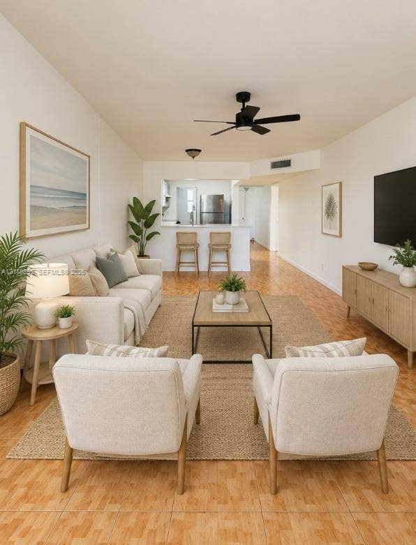 Living area featuring parquet flooring, a ceiling fan, and an open pass-through window to the kitchen