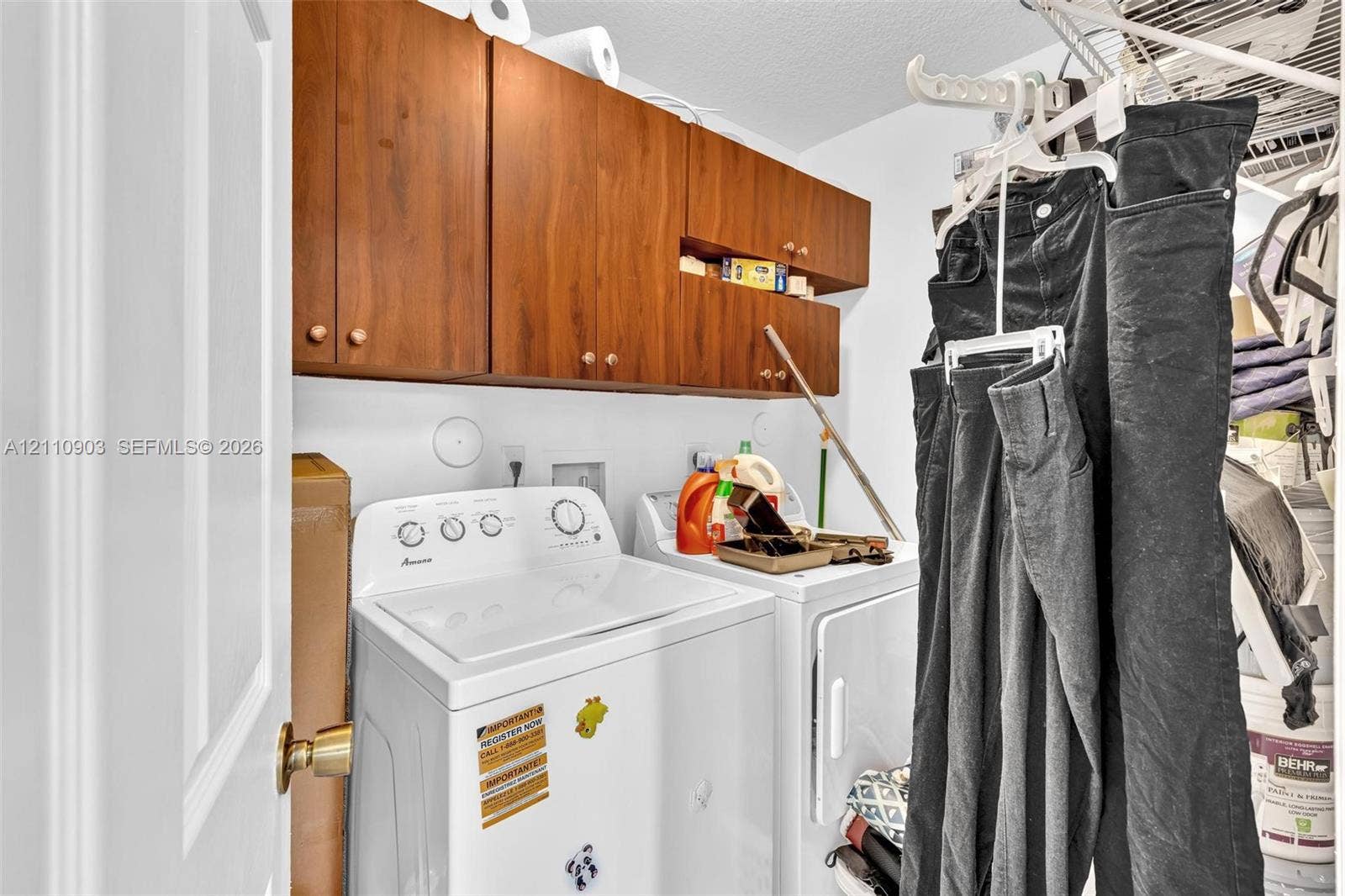 Laundry room featuring wooden wall-mounted cabinetry and wire shelving