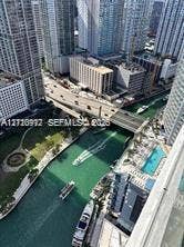 High-rise exterior balcony perspective featuring a swimming pool, waterfront access to the canal, and urban skyline surroundings