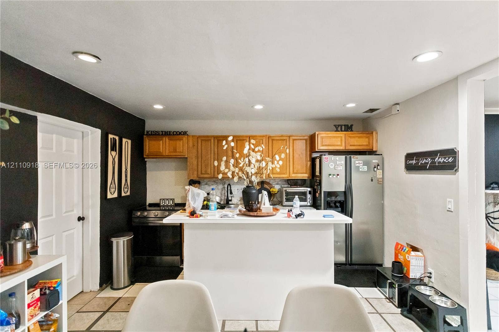 2007 NW 89th Street, Miami, FL 33147 Kitchen featuring wood cabinetry, a central island with a white countertop, recessed lighting, and tile flooring
