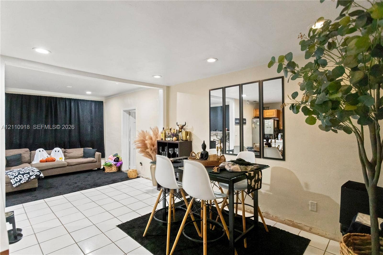 2007 NW 89th Street, Miami, FL 33147 Open-concept interior featuring light-toned tile flooring, recessed ceiling lighting, and a multi-pane decorative wall mirror