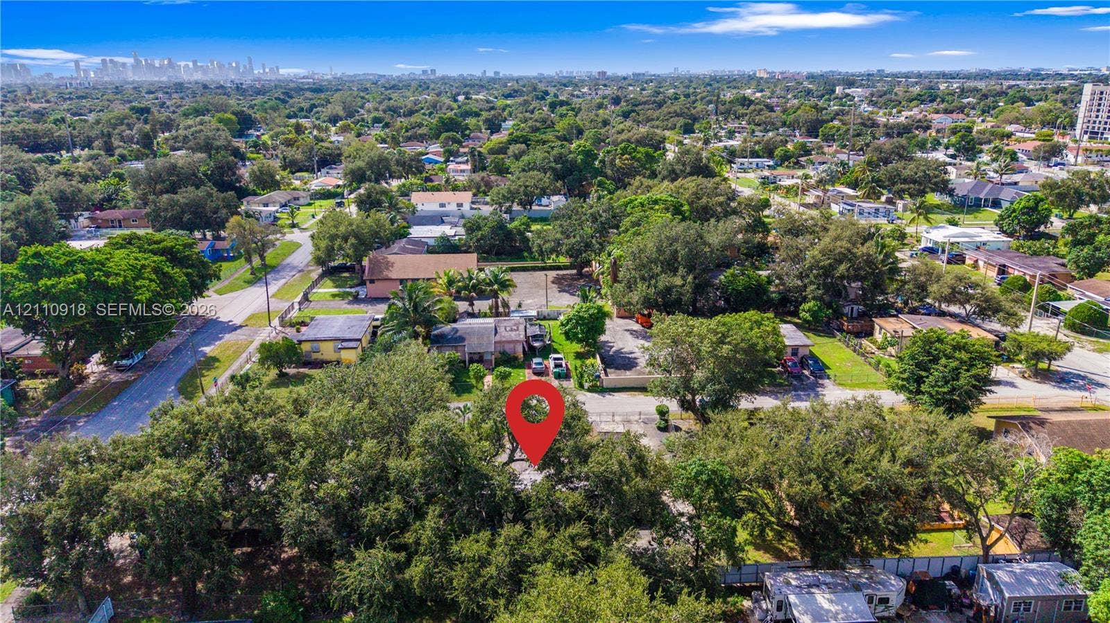 2007 NW 89th Street, Miami, FL 33147 Aerial perspective showcasing a parcel of land featuring mature canopy trees and an urban skyline backdrop