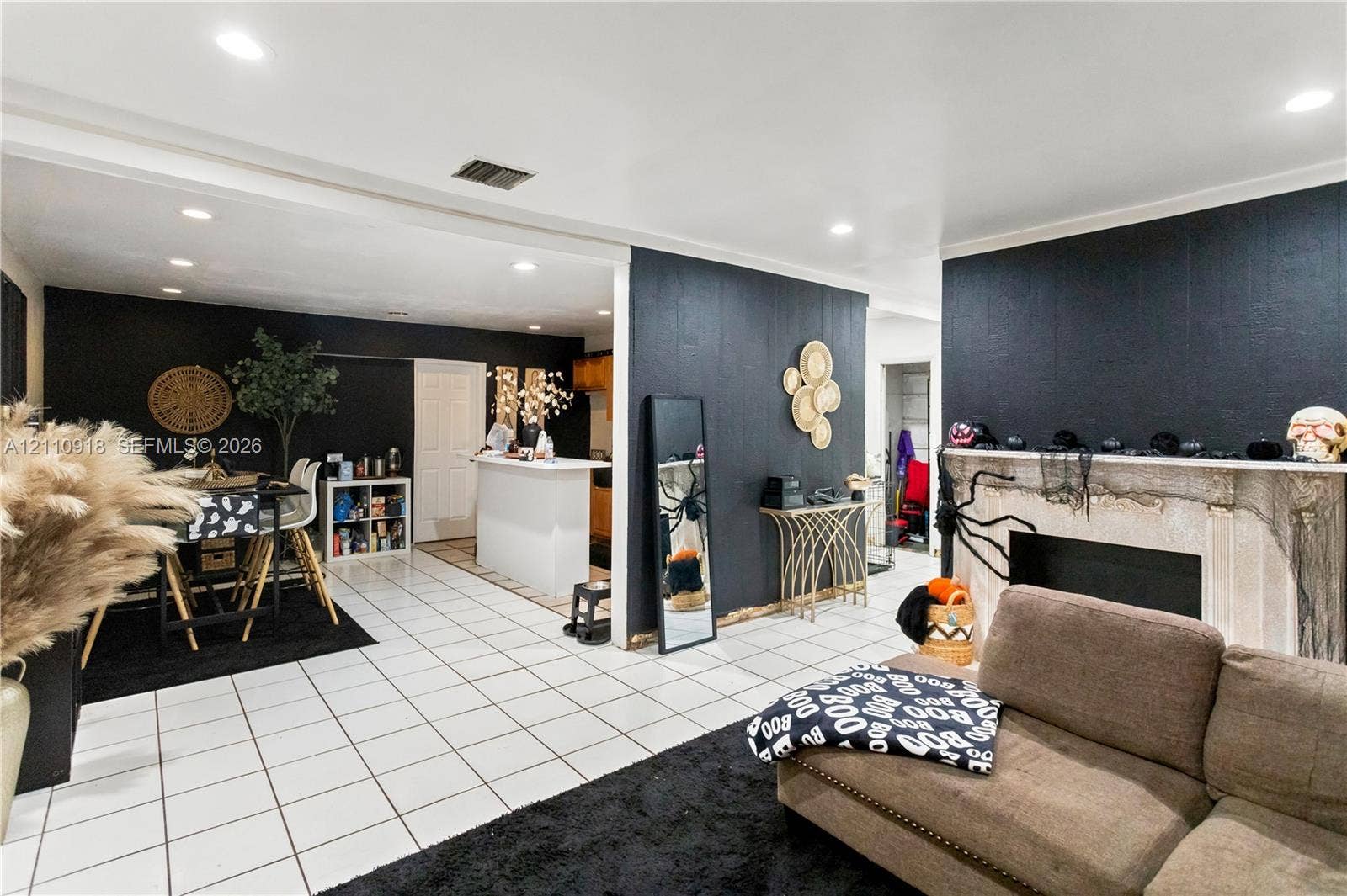 2007 NW 89th Street, Miami, FL 33147 Open-concept interior featuring light-toned tile flooring, recessed ceiling lighting, and a fireplace with a stone-finish surround