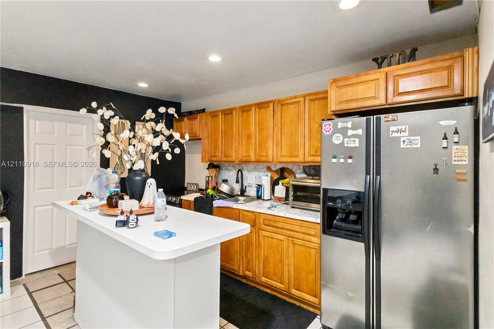 2007 NW 89th Street, Miami, FL 33147 Kitchen featuring natural wood cabinetry, white countertops, recessed lighting, and a stainless steel refrigerator