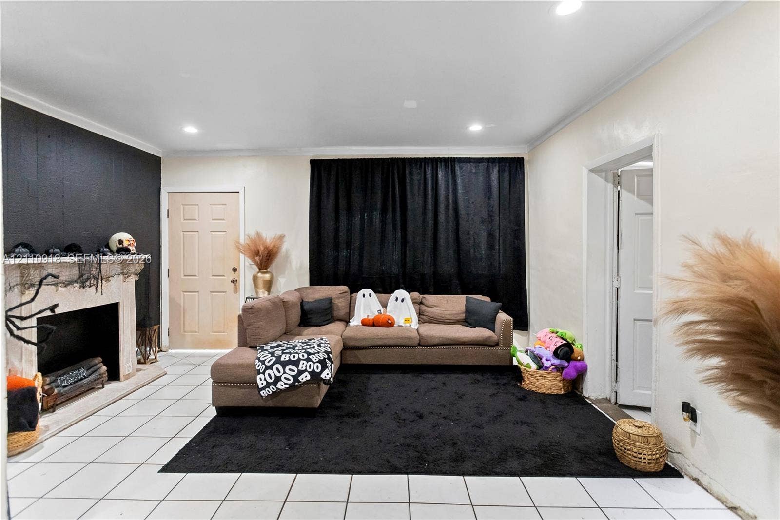 2007 NW 89th Street, Miami, FL 33147 Living area featuring large-format tile flooring, recessed lighting, and a prominent fireplace with a decorative stone-finish mantel