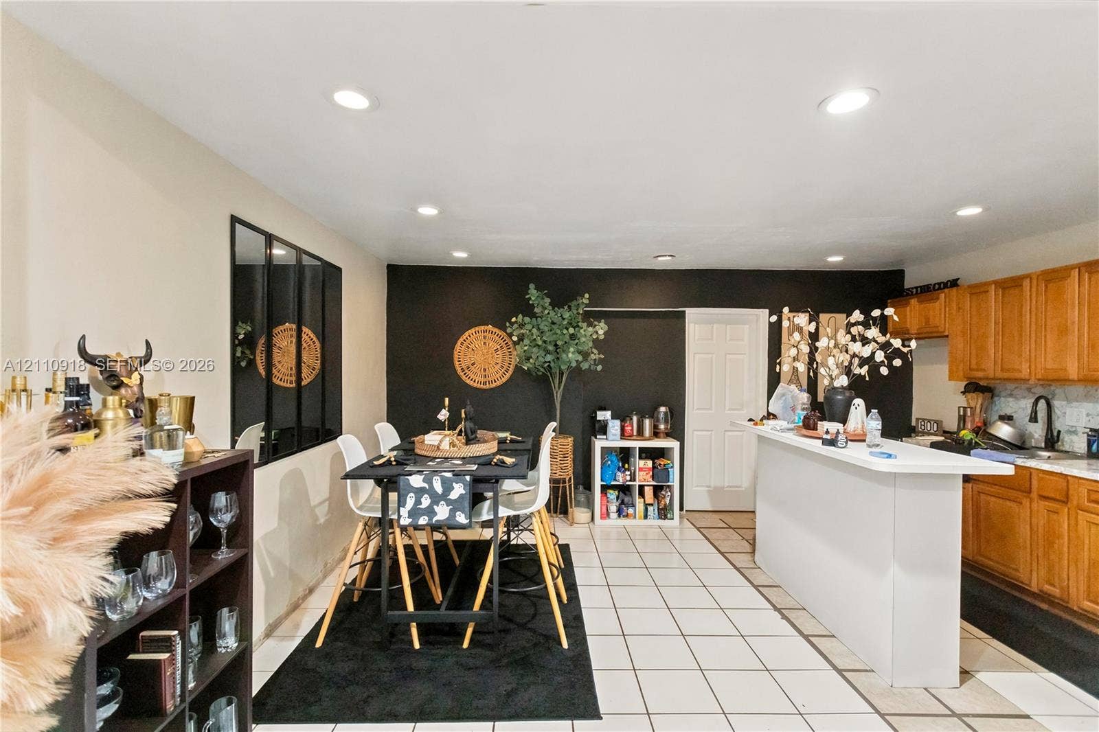 2007 NW 89th Street, Miami, FL 33147 Kitchen featuring wood cabinetry, white countertops, a breakfast bar, recessed lighting, and tile flooring