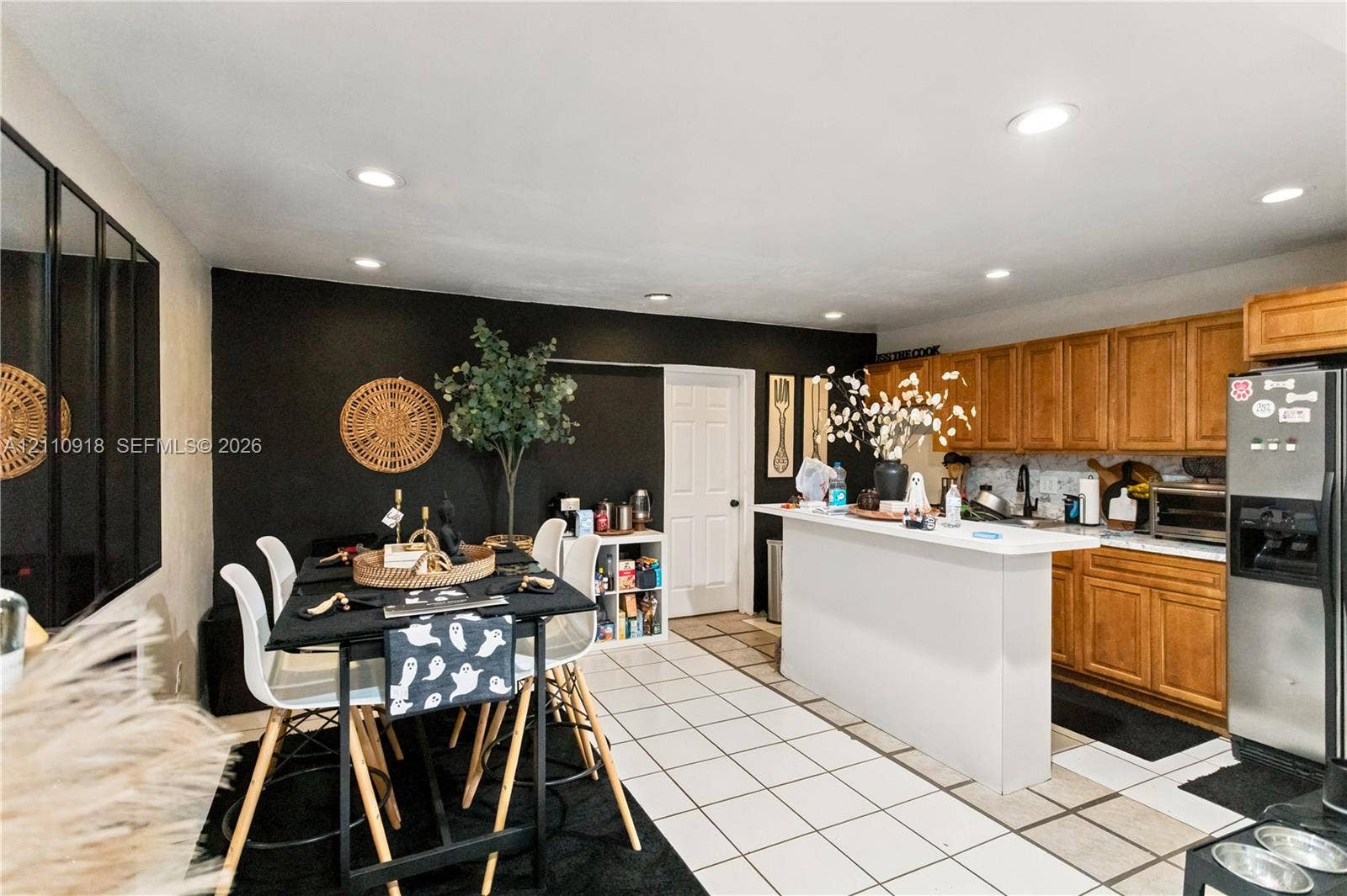 2007 NW 89th Street, Miami, FL 33147 Kitchen featuring light wood cabinetry, white tile flooring, recessed ceiling lighting, and a peninsula island with a solid surface countertop