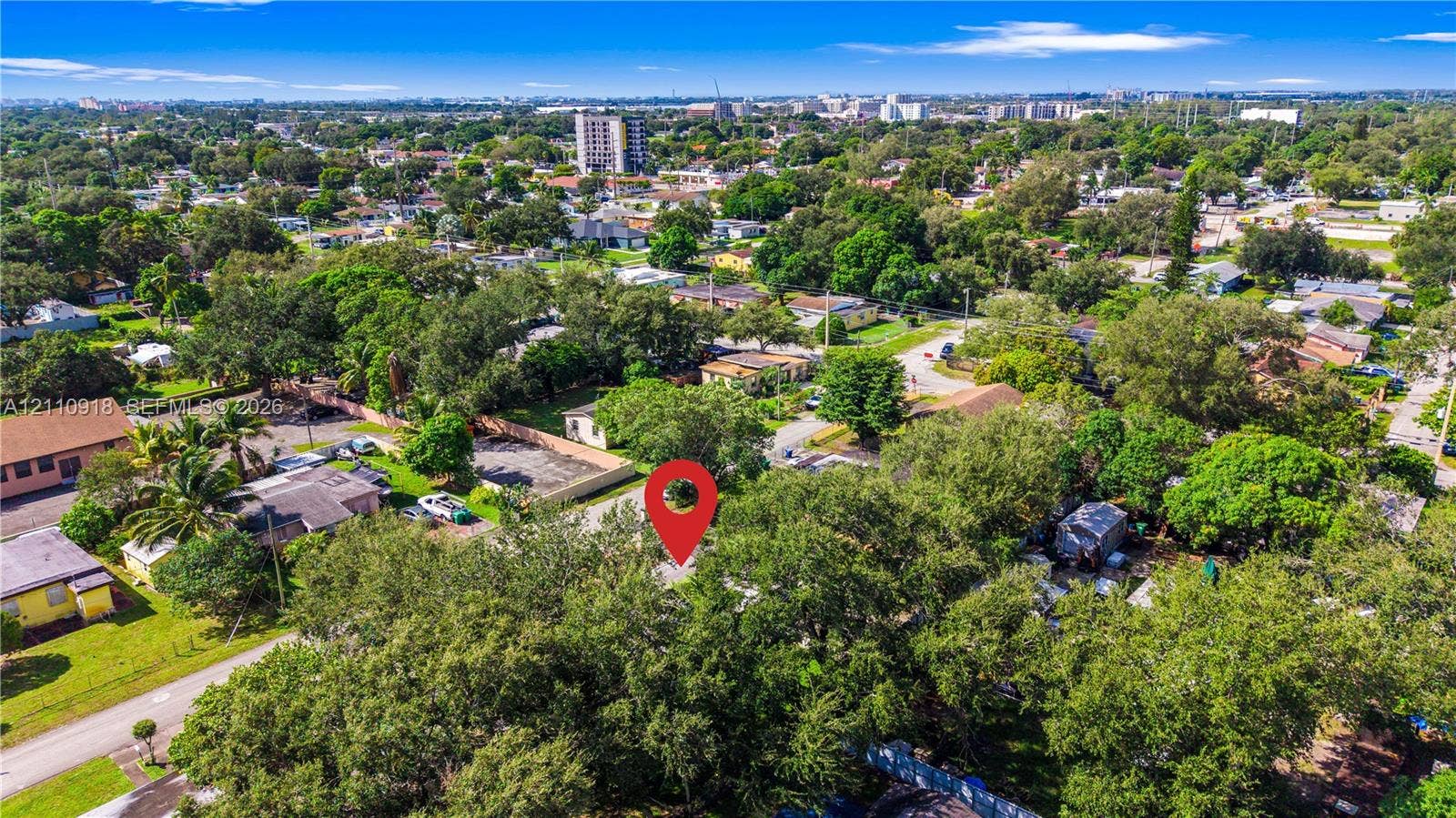 2007 NW 89th Street, Miami, FL 33147 Aerial perspective featuring a residential lot characterized by mature tree canopy and paved street access within an established suburban setting