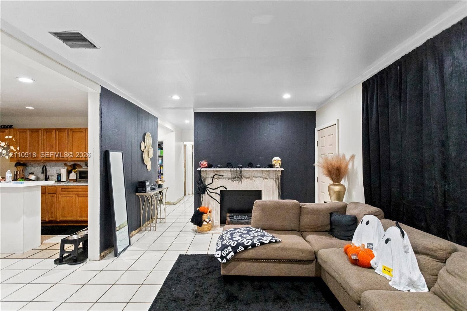 2007 NW 89th Street, Miami, FL 33147 Open-concept interior featuring light-toned tile flooring, recessed lighting, and a prominent fireplace with a decorative mantel