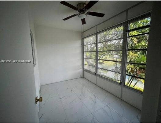 5003 NW 35th Street, #506, Lauderdale Lakes, Lauderdale Lakes, FL 33319 Sunroom featuring large-format tile flooring, multi-pane windows, and a ceiling fan with integrated lighting