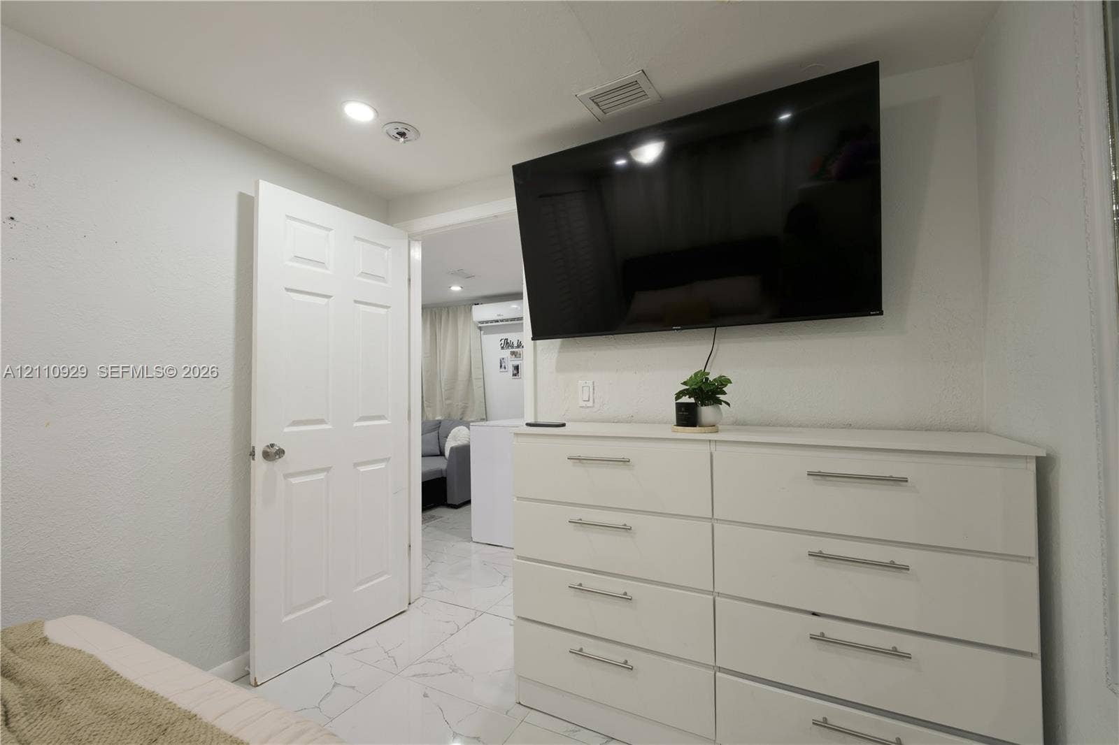 Interior space featuring polished stone-finish tile flooring, recessed ceiling lighting, and a solid-core panel door