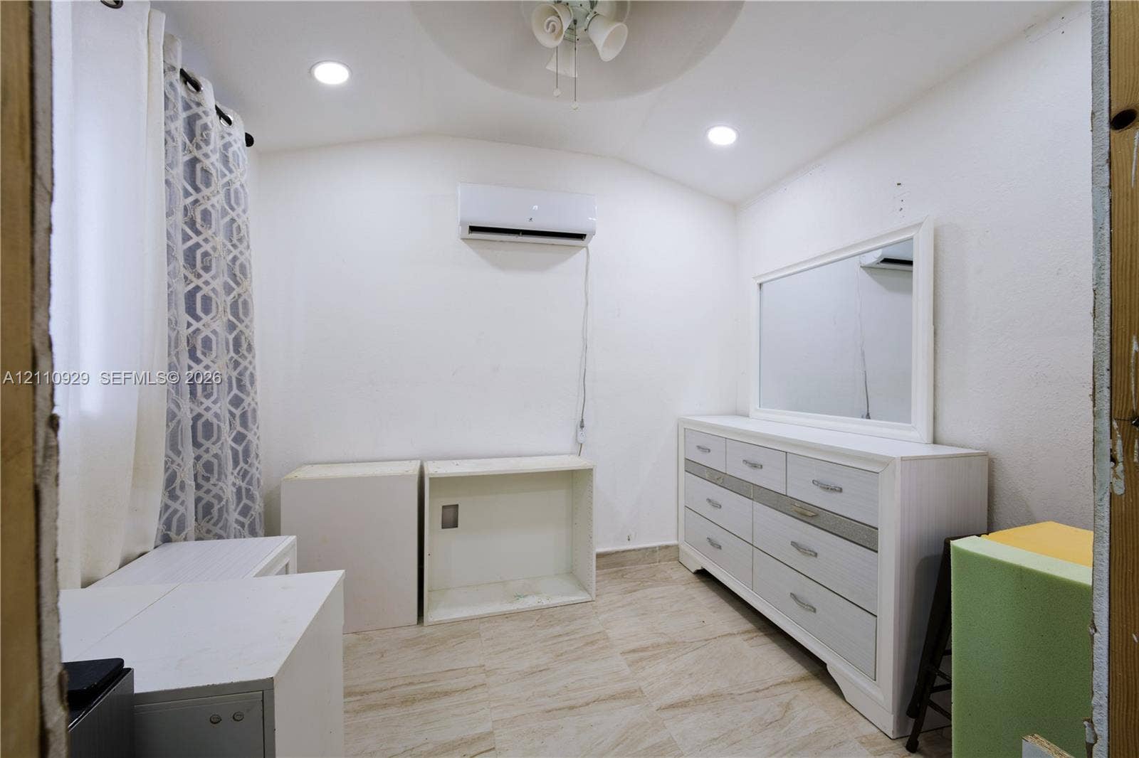 Room featuring recessed ceiling lighting, a wall-mounted ductless air conditioning unit, and tile flooring