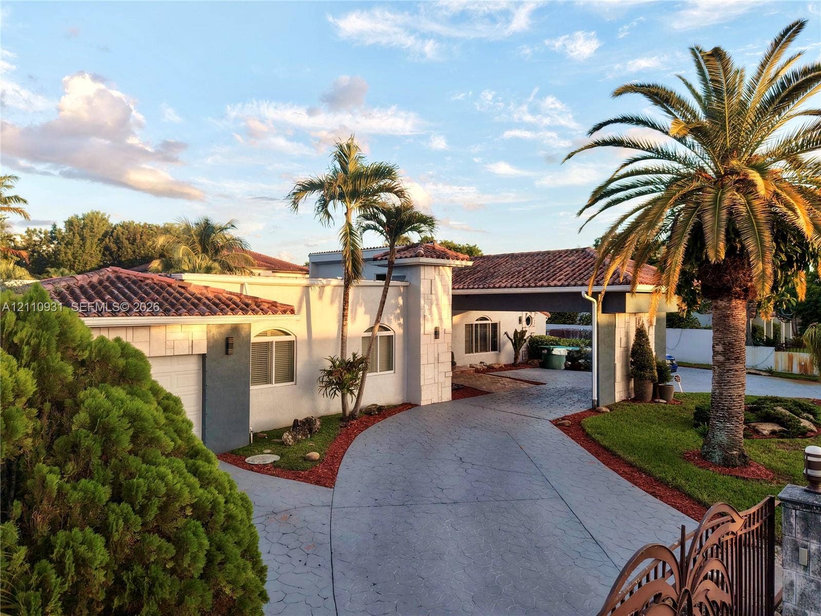 3005 SW 99th Court, Miami, FL 33165 Single-story exterior featuring a clay tile roof, arched windows, covered carport, and paved circular driveway