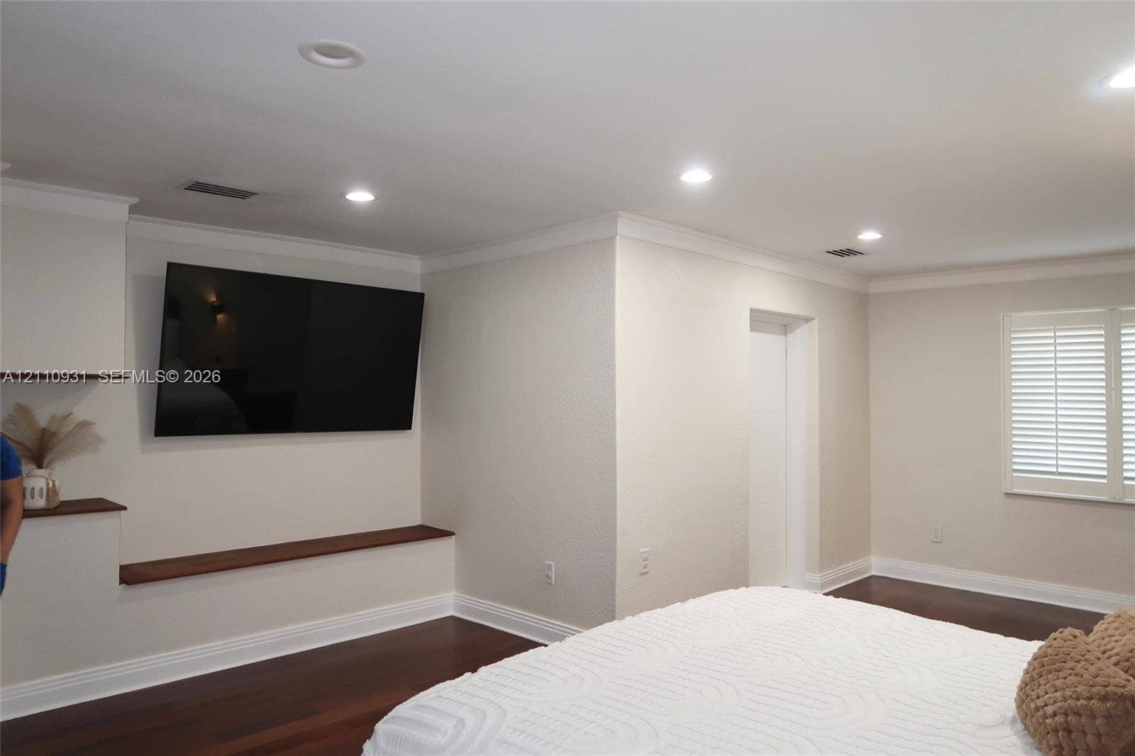 3005 SW 99th Court, Miami, FL 33165 Dark wood-finish flooring, recessed lighting, crown molding, integrated wood-finish shelving, and plantation shutters