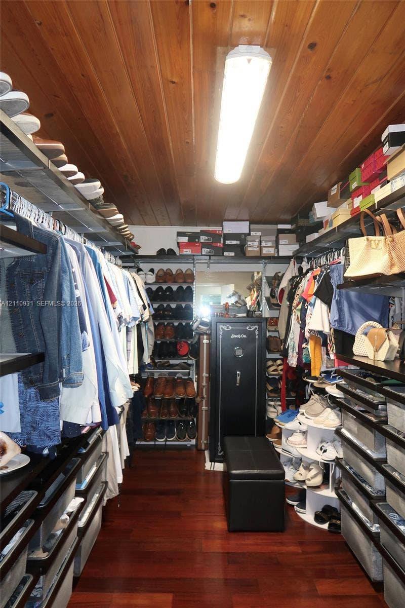 3005 SW 99th Court, Miami, FL 33165 Walk-in storage space featuring wood-finish flooring, paneled wood ceiling, tiered shelving, and built-in linear ceiling lighting