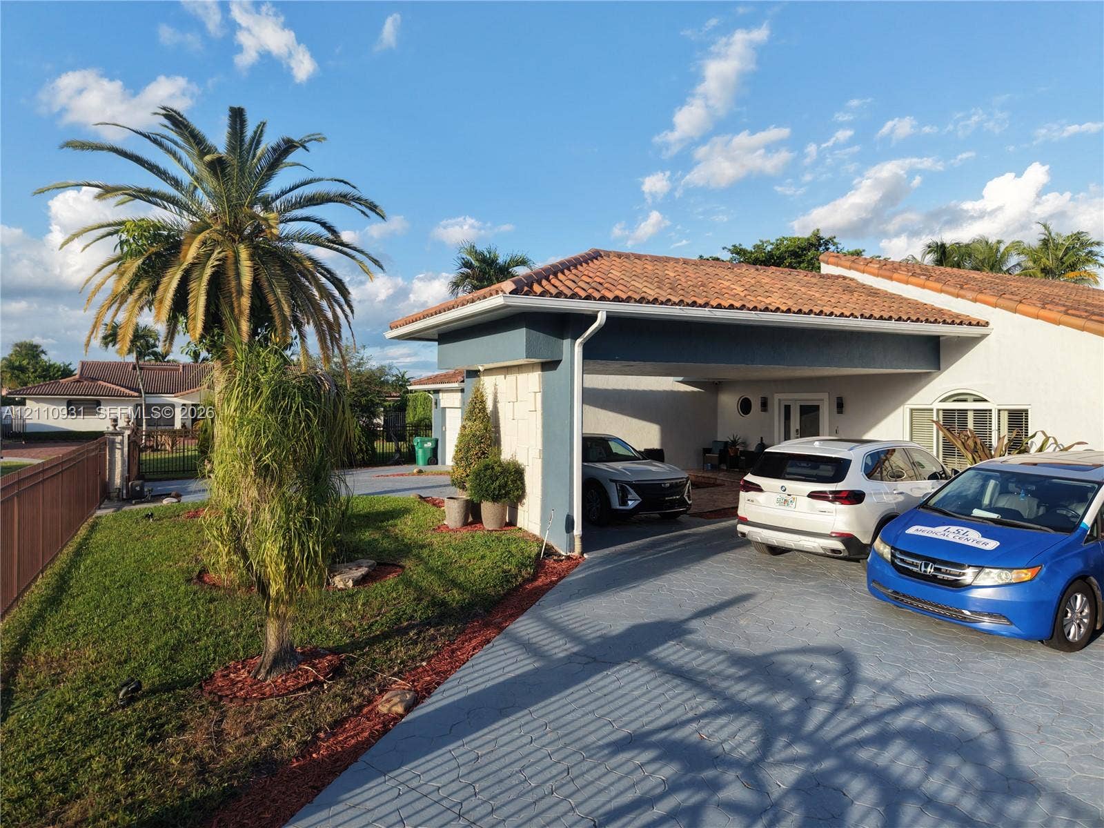 3005 SW 99th Court, Miami, FL 33165 Single-story exterior featuring a clay tile roof, attached covered carport, textured stucco facade, and a stamped concrete driveway