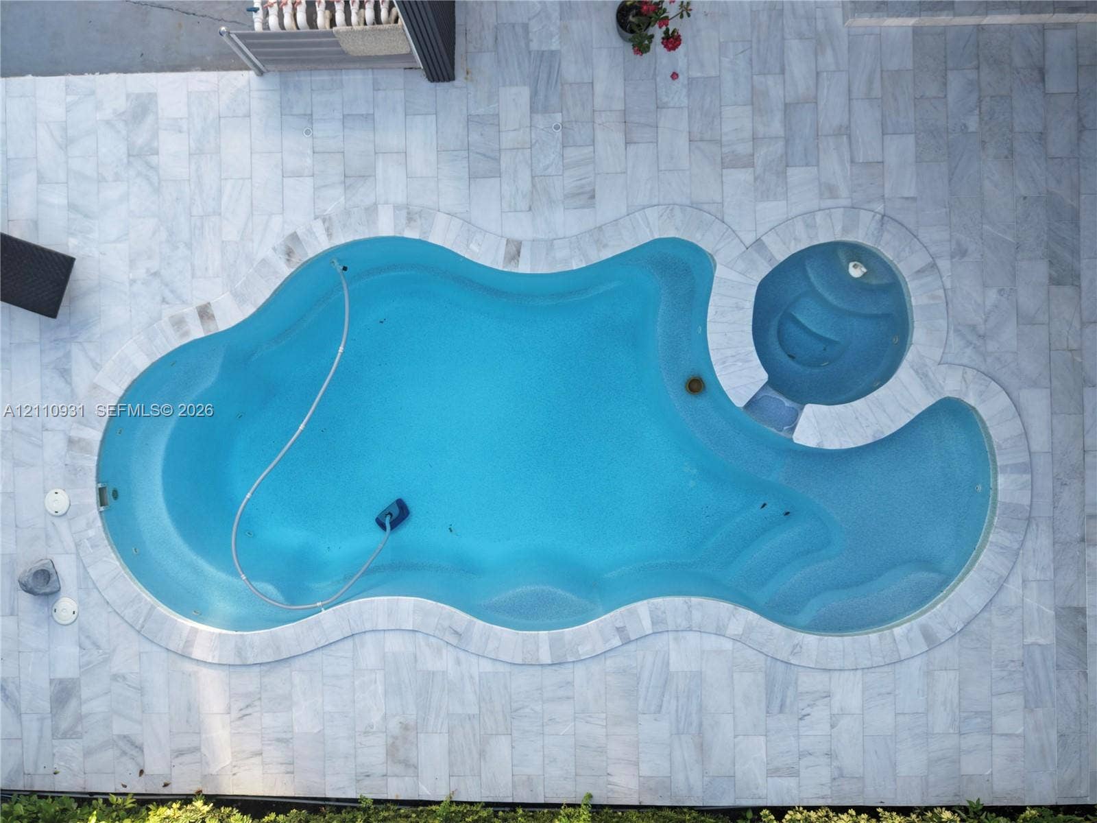 3005 SW 99th Court, Miami, FL 33165 Freeform swimming pool with integrated spa, surrounded by natural stone paver decking