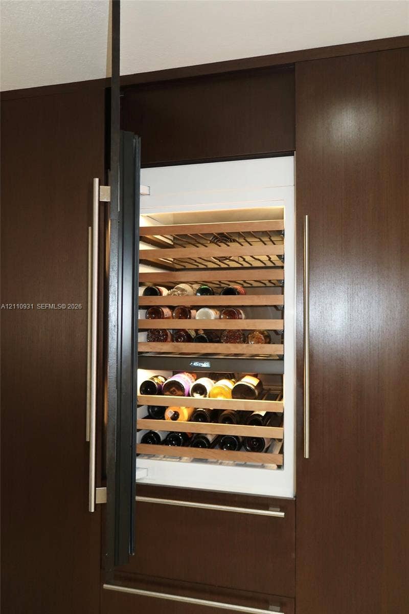 3005 SW 99th Court, Miami, FL 33165 Built-in wine refrigerator featuring wood shelving, integrated cabinetry, and vertical stainless steel hardware