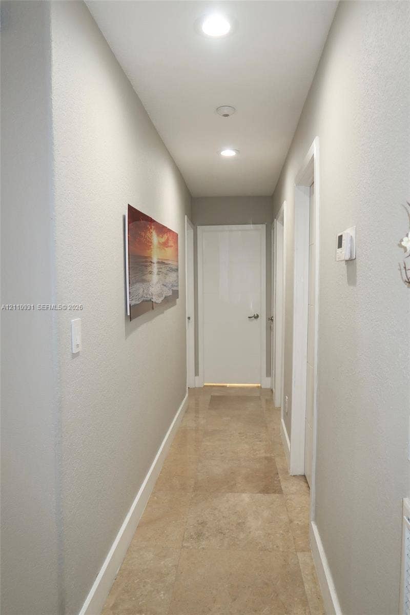 3005 SW 99th Court, Miami, FL 33165 Hallway featuring large-format tile flooring, recessed ceiling lighting, and crisp white interior doors
