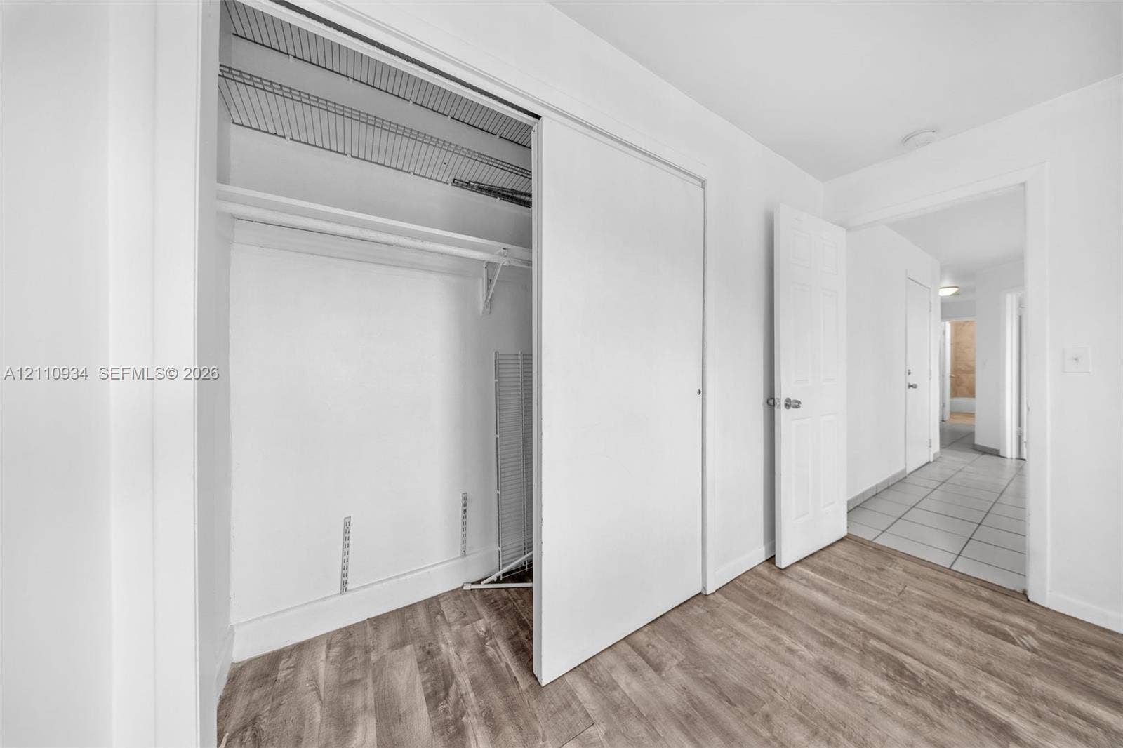 Closet featuring sliding doors and wire shelving with wood-finish flooring throughout the room